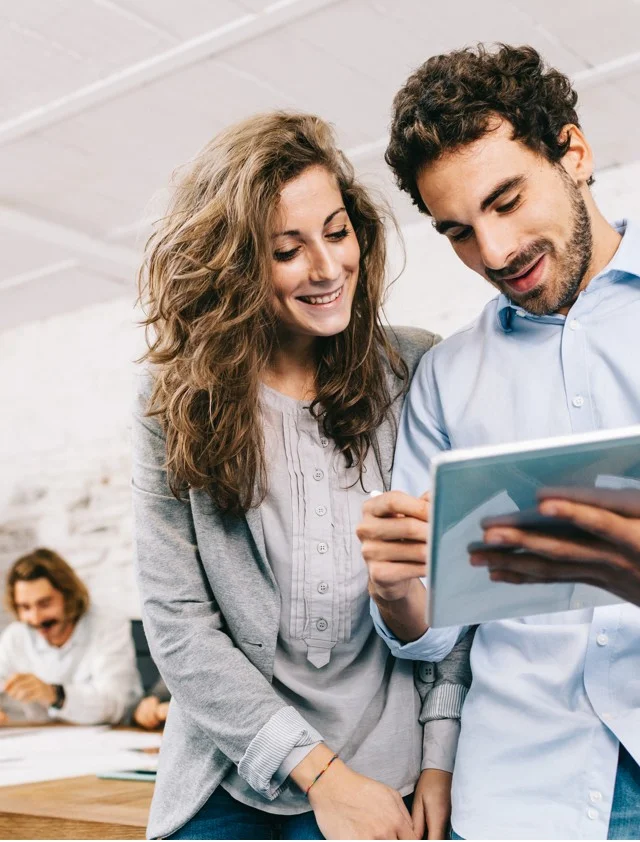 Two happy people looking at a tablet